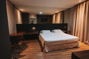 卡夸尔Catuai Hotel的酒店客房配有一张床铺和一张桌子。