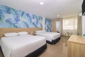 圣安德烈斯Hotel Bahia Sardina的酒店客房带两张床和热带壁纸。