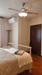 米利亚里诺La villetta d' angolo的一间卧室配有一张带吊扇的床