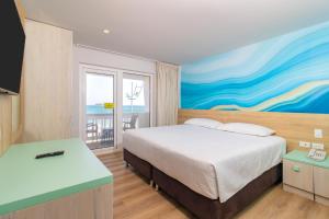 圣安德烈斯Hotel Bahia Sardina的卧室配有一张床,墙上挂有绘画作品