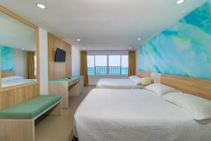 圣安德烈斯Hotel Bahia Sardina的配有大窗户的酒店客房内的两张床