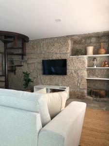 维埃拉·多米尼奥Sobreiro Valley - Casa Isabel的客厅配有沙发和石墙电视。