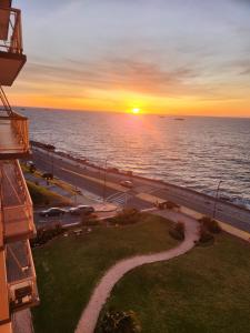马德普拉塔Hermoso 2 ambientes en la costa con vista al mar的从大楼的阳台上欣赏海洋上的日落