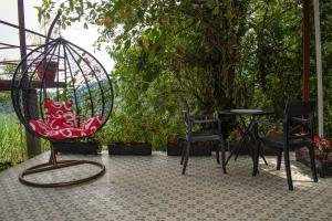 明多GLAMPING MINDO SUYANA的庭院配有椅子、秋千和桌子