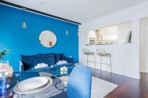 圣芒代Charming 4P apartment Saint Mande的蓝色的客厅配有蓝色的沙发和玻璃桌