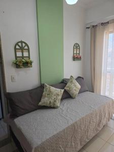 卡尚布Hospedagem Flat verde Sul de Minas的卧室内的一张带两个枕头的床