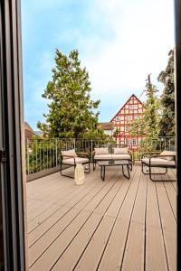 兰河畔马尔堡Himmlische Altstadt-Maisonette的木甲板上设有长椅和桌子