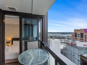 奥克兰Stunning Apartment Amazing View near Sky Tower的阳台设有玻璃桌,享有城市美景。