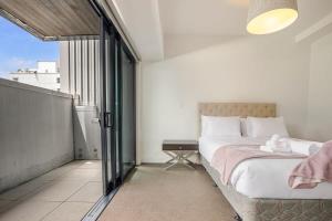 奥克兰Bright & modern Auckland CBD apartment的一间卧室设有一张床和一个大窗户