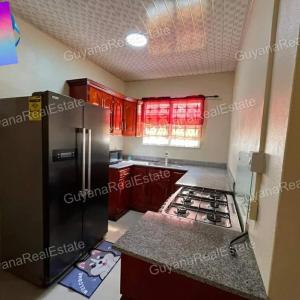 乔治敦S&S Guyana Real Estate Apartment的厨房配有冰箱和炉灶。
