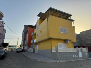 普拉亚BemVinda Sweet Home - Cama Mesa e Fogão的街道边的黄色建筑