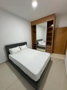 普拉亚BemVinda Sweet Home - Cama Mesa e Fogão的一间卧室配有一张大床和镜子