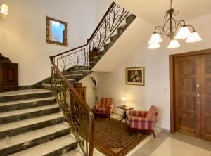 莫斯塔Maltese Garden Villa的客厅的楼梯,配有两把椅子