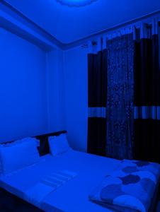 基加利URBAN VIBER MOTEL的一间卧室配有一张蓝色的灯光床