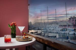 热那亚热那亚码头NH典藏酒店的一张桌子,上面有花瓶,还有一个窗户,上面有船