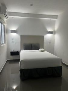 巴拿马城Hotel HSR的卧室配有一张白色大床