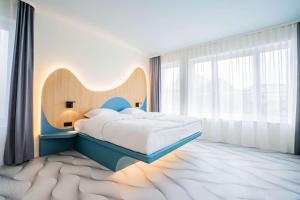 德累斯顿prizeotel Dresden-Mitte的一间卧室设有一张床和一个大窗户