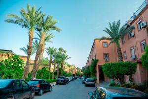 马拉喀什Riad The Moroccans Pool And Terrace的一条棕榈树和汽车林立的街道