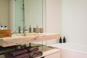 里斯本Apartment in Santos的浴室配有盥洗盆、镜子和毛巾
