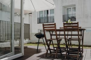 里斯本Apartment in Santos的庭院里设有两把椅子和一张桌子及一把遮阳伞