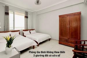 岑山Khách sạn Hà Nội 2 Mặt Biển Sầm Sơn的一间卧室配有一张床和一个木制橱柜
