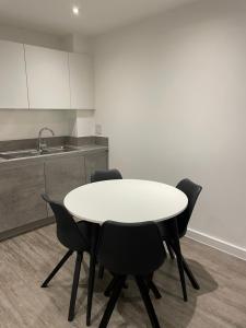 巴尔金Luxurious 2 Bedroom Apartment的厨房里配有一张白色的桌子和黑色的椅子