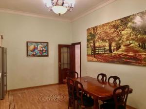 巴库Luxury villa 8 bedrooms的一间设有桌子和墙上绘画的用餐室