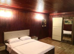 巴库Luxury villa 8 bedrooms的一间卧室设有一张床和木墙