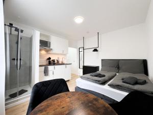 杜塞尔多夫Cityapartments Düsseldorf - Stadtmitte的一间卧室配有一张床铺和一张桌子,还设有一间厨房