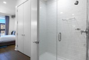 霍博肯Dharma Home Suites Hoboken的带淋浴的浴室和玻璃门