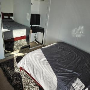 布里斯班Bedroom & Private Bathroom in Modern Inner Brisbane Apartment的一间卧室配有一张床和镜子