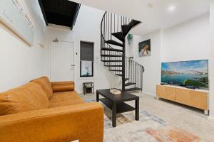 悉尼Cosy Camperdown的带沙发和螺旋楼梯的客厅
