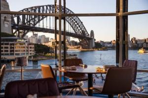 悉尼Terrace Boutique in the Heart of The Rocks的一张桌子和椅子,享有桥梁的景色