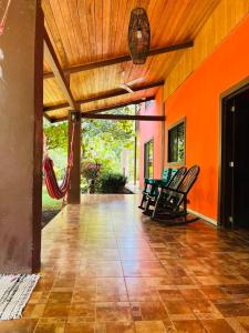 Santa RosaVilla Toscana的一个带椅子和橙色墙壁的开放式门廊