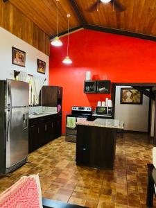 Santa RosaVilla Toscana的一间设有红色墙壁和不锈钢用具的大厨房