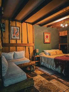 富特罗诺Cabañas Pewma Futrono的一间卧室配有两张床和一张沙发。