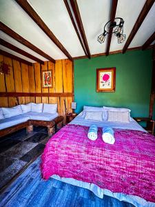 富特罗诺Cabañas Pewma Futrono的一间卧室配有一张带粉色毯子的大床