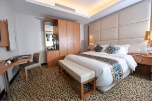 吉达Grand Park by VERTA的酒店客房设有一张大床和一张书桌。