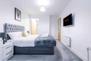 曼彻斯特Luxury 2BR Apartment in Central *FREE PARKING*的一间卧室配有一张床和一台平面电视