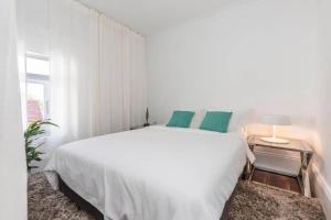 悉尼Modern Sydney Surry Hills Century Cottage的白色卧室配有带绿色枕头的大型白色床