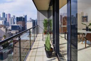 墨尔本Penthouse Apartment in Melb CBD Perfect Location的阳台种有盆栽植物,享有城市美景