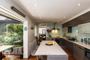 悉尼3 Bedroom House With Large Courtyard & City Views的厨房配有白色的大桌子和椅子