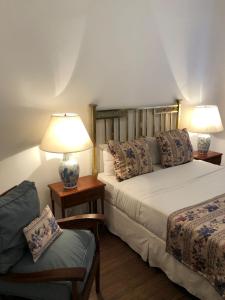 乌拉圭河畔康塞普西翁Gran Texier Hotel Casino的一间卧室配有两张床、一盏灯和一把椅子