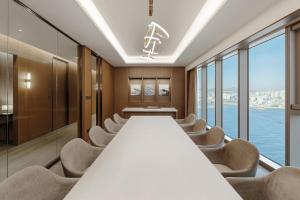 釜山Wyndham Grand Busan的长长的会议室,配有长桌子和椅子