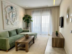 卡萨布兰卡Maârif Cosy Apartment - Dynasty Estate的客厅配有绿色沙发和茶几