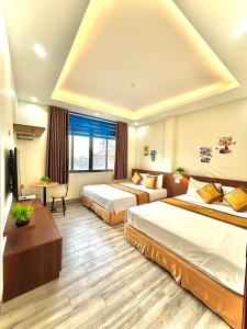 岑山Khách sạn Xanh Tốt FLC Sầm Sơn的酒店客房配有两张床和一张书桌