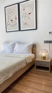 卡萨布兰卡Maârif Cosy Apartment - Dynasty Estate的卧室配有一张墙上三幅照片的床