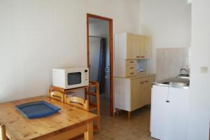 卡尔维Residence Thalassa的一间带桌子和微波炉的小厨房