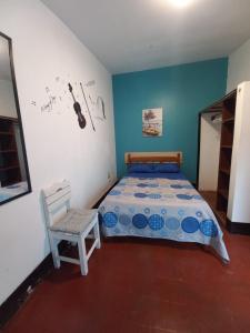 万查科El Boquerón - Hospedaje的一间卧室配有一张床和一把椅子