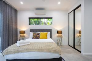 艾吉希尔Hamptons Spa Villa - Luxury 3 bedroom 2 bathroom home with outdoor Hot tub的一间卧室配有一张带黄色枕头的大床